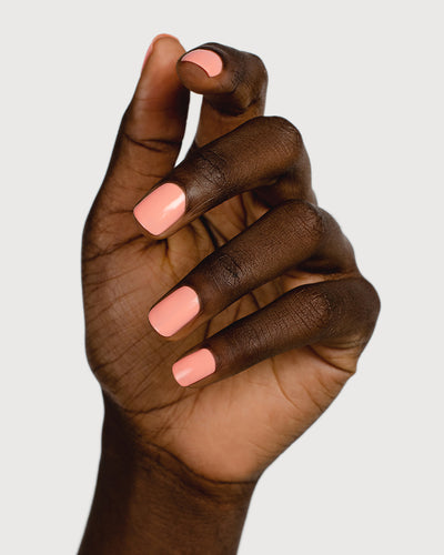 Vibrant peach nail polish hand swatch on dark skin tone
